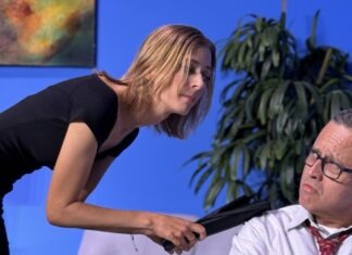 a woman standing next to a man on a couch