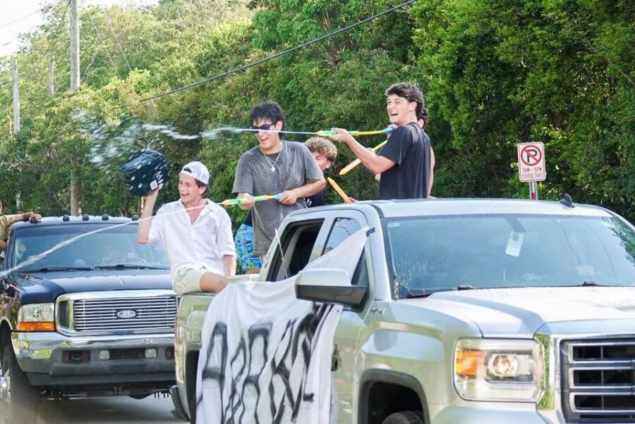 a group of people standing on the back of a pick up truck