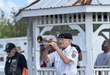 a man playing a trumpet in front of a group of people