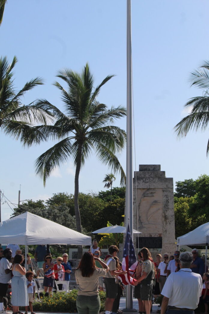 a group of people standing around a flag pole
