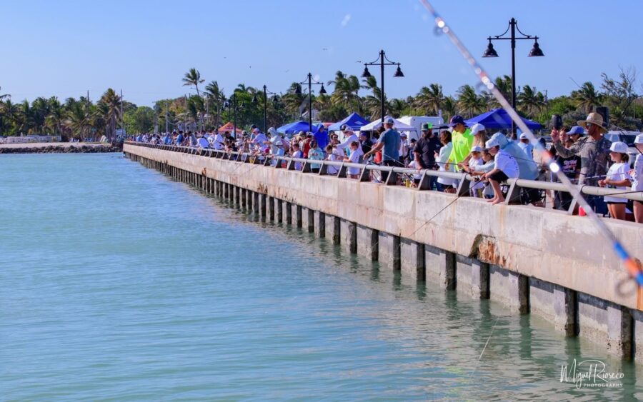a group of people standing next to a body of water