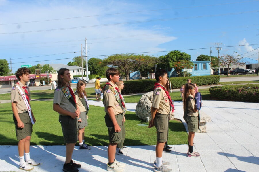 a group of young people standing on top of a grass covered field