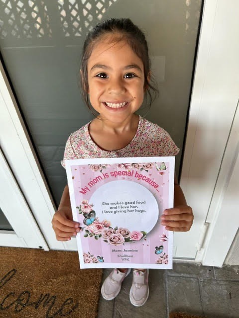 a little girl holding up a card with a message on it