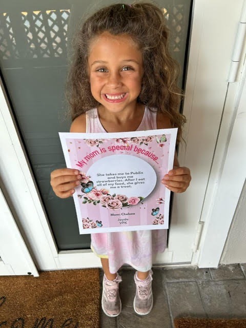 a little girl holding a sign that says happy school day