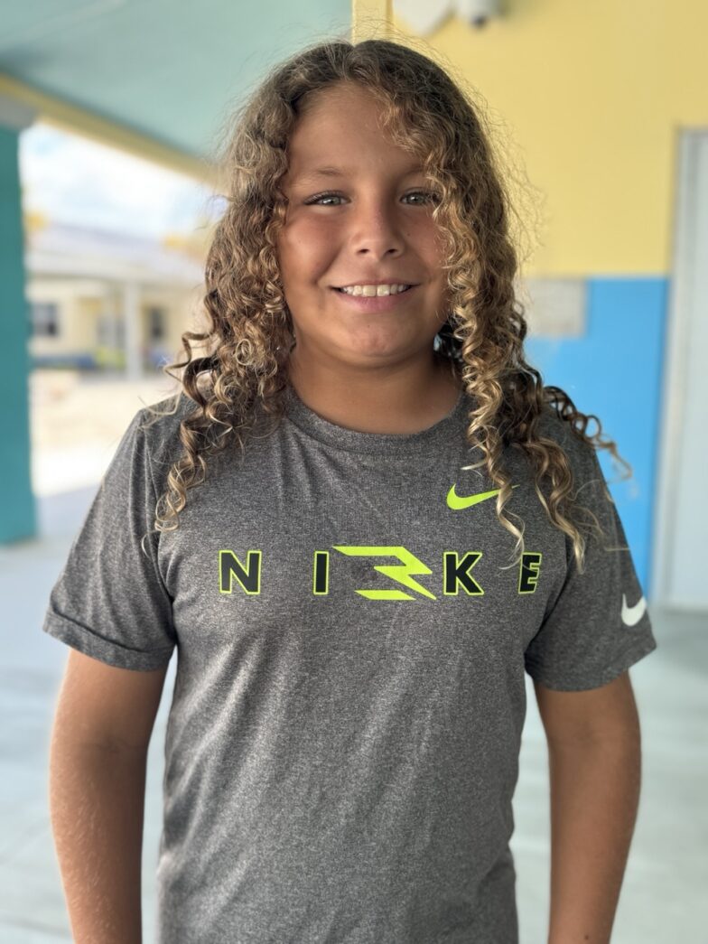 a girl with curly hair wearing a nike shirt