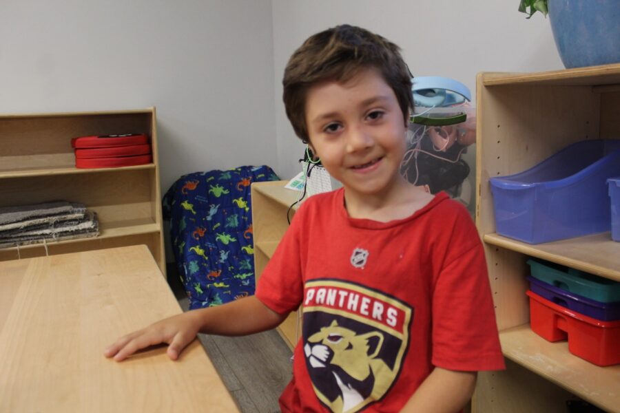 a young boy sitting at a desk in a classroom