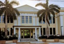 a large white building with palm trees in front of it