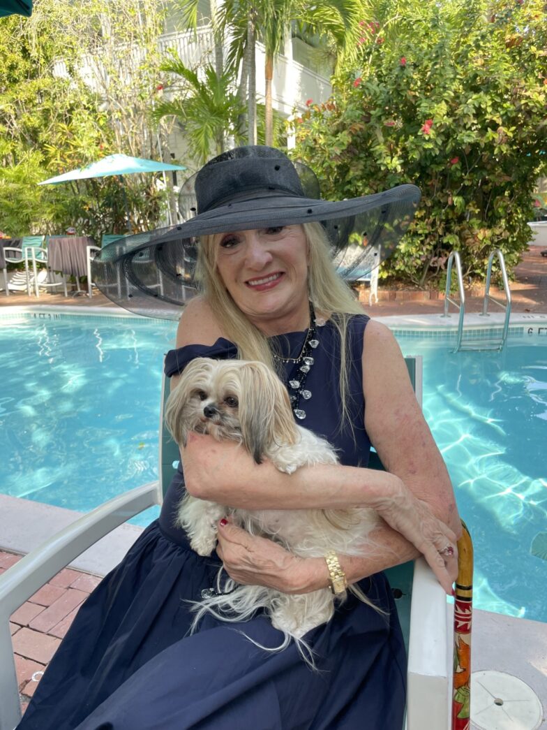 a woman sitting on a chair holding a dog
