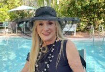 a woman sitting in a chair next to a pool wearing a hat