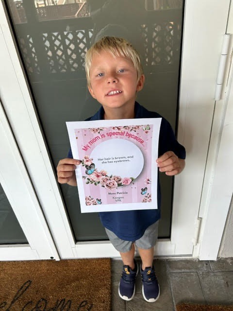 a young boy holding up a picture of himself