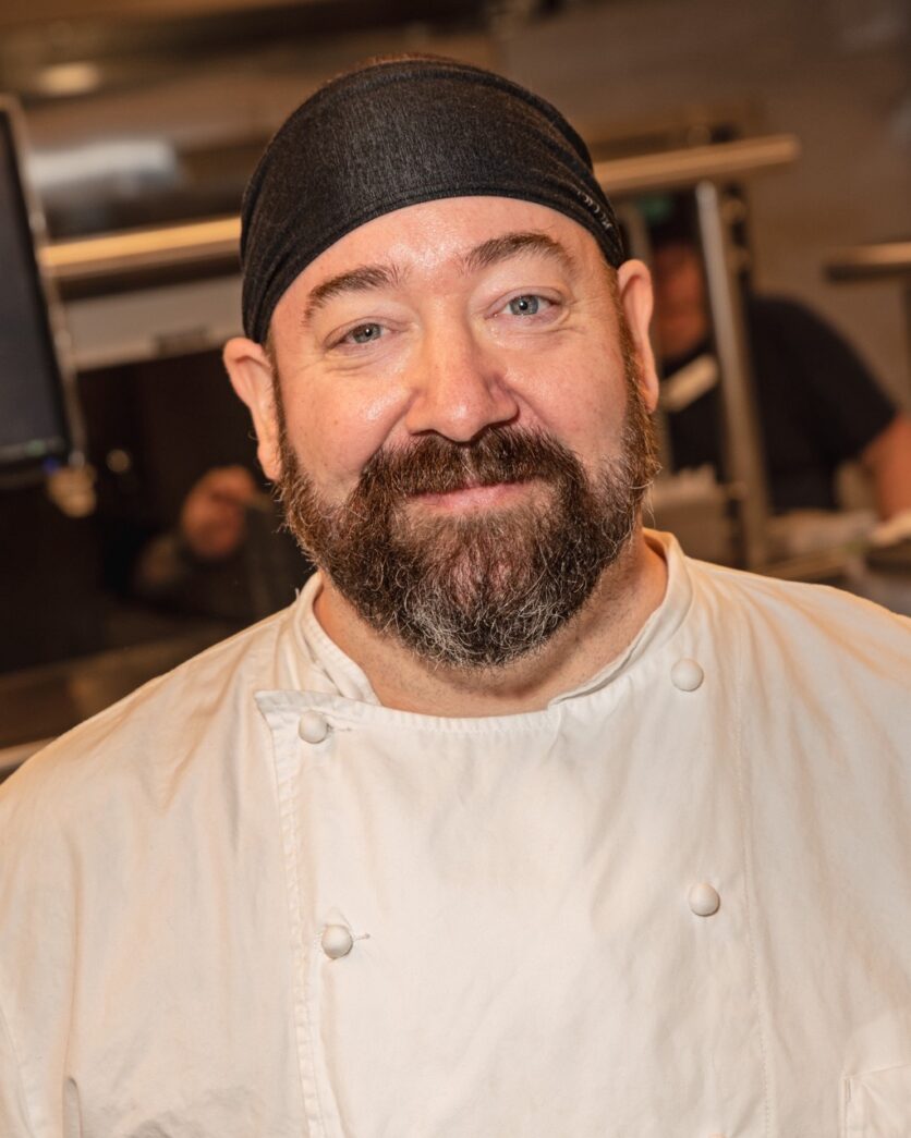 a man with a beard wearing a chef's hat