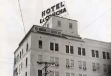 a tall white building with a sign on top of it