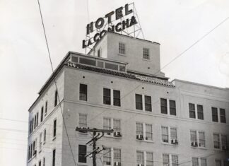 a tall white building with a sign on top of it