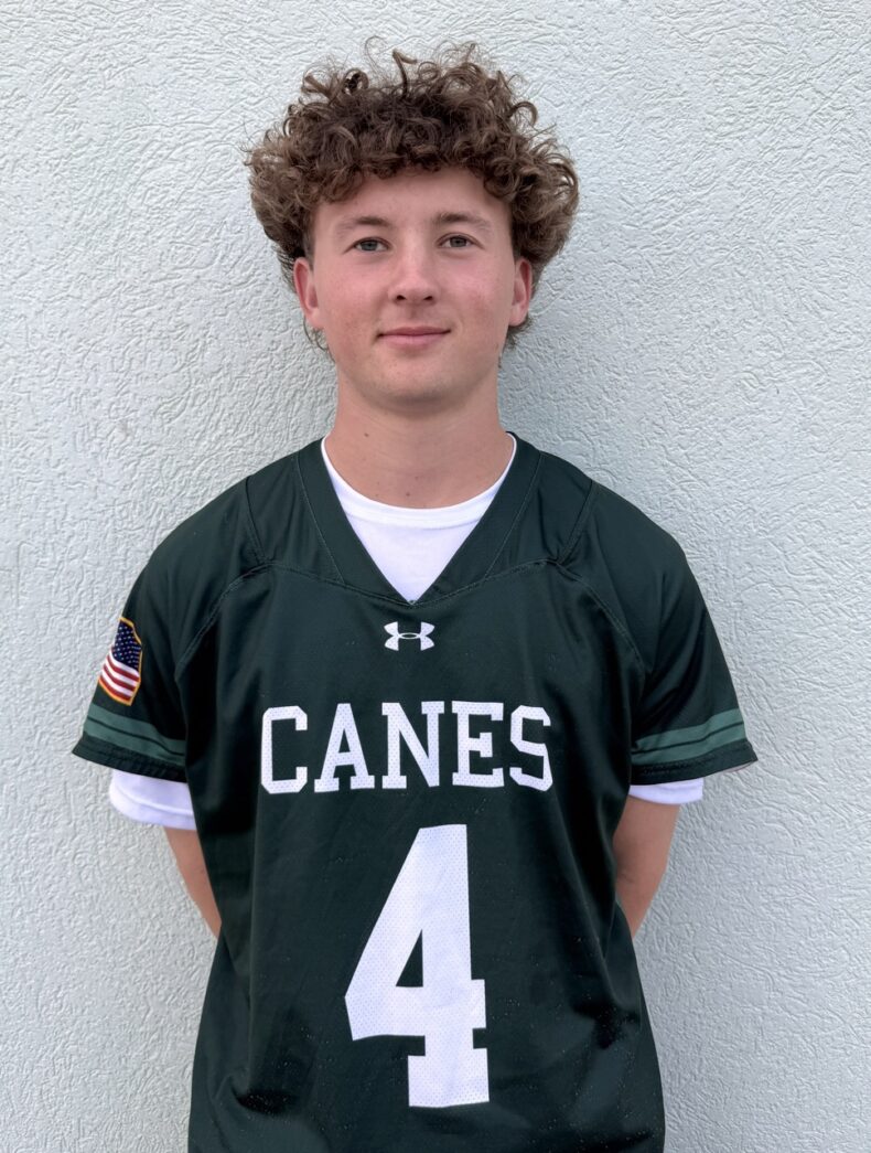 a young man wearing a football uniform standing in front of a wall