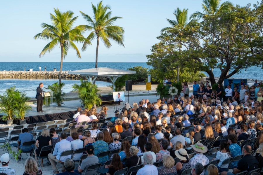 a crowd of people sitting in chairs in front of the ocean