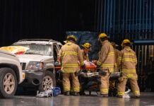 a group of firefighters standing next to a car