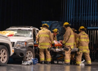 a group of firefighters standing next to a car