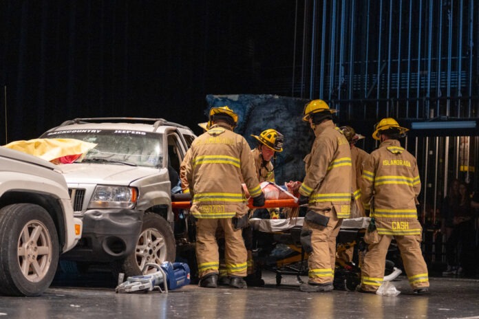 a group of firefighters standing next to a car