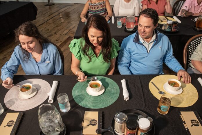 NEW_5211 Large a group of people sitting around a table eating food