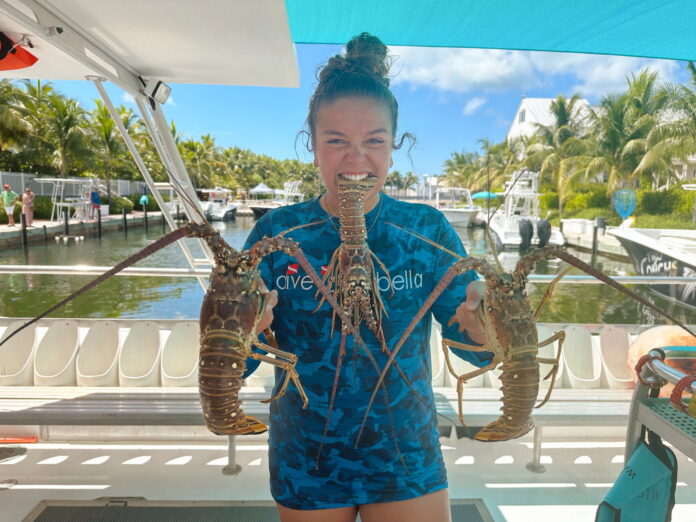 NOTW Cheyenne G 2 a woman holding a large lobster on a boat