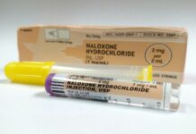 a tube of naloxone hydrochloride next to a box of