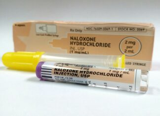 a tube of naloxone hydrochloride next to a box of