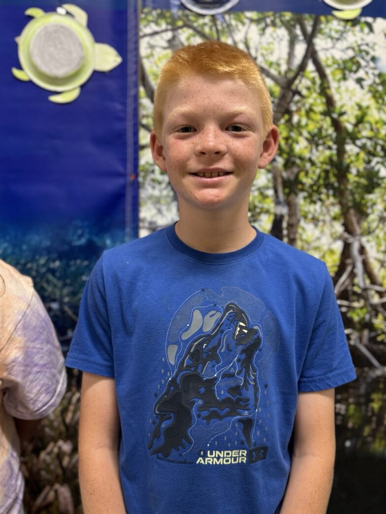 a young boy standing next to another young boy