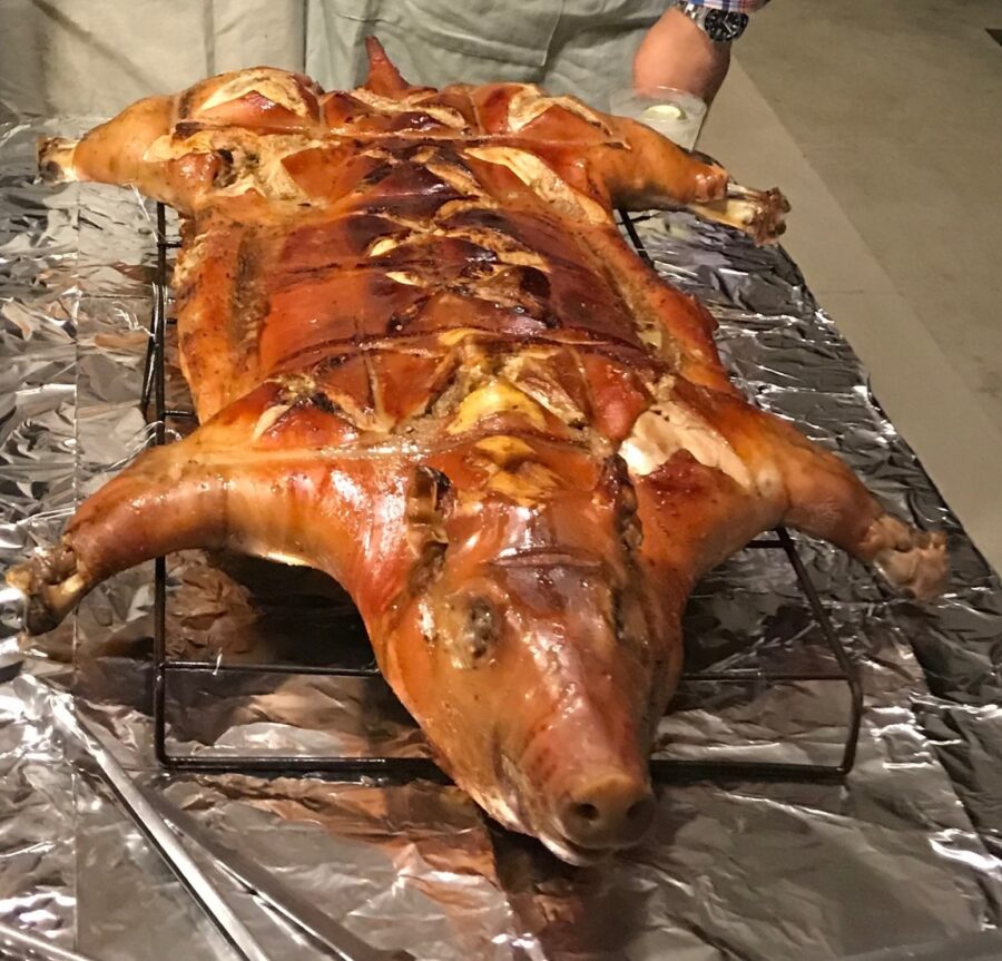 a man standing next to a large piece of meat