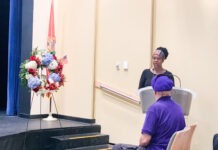 a woman standing at a podium in front of a group of people