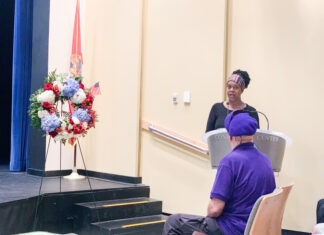a woman standing at a podium in front of a group of people