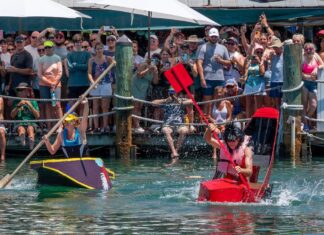 a group of people riding paddle boats on top of a body of water