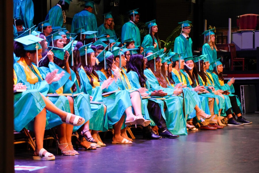 a group of graduates sitting on a stage