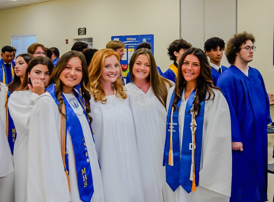 a group of people in graduation gowns posing for a picture