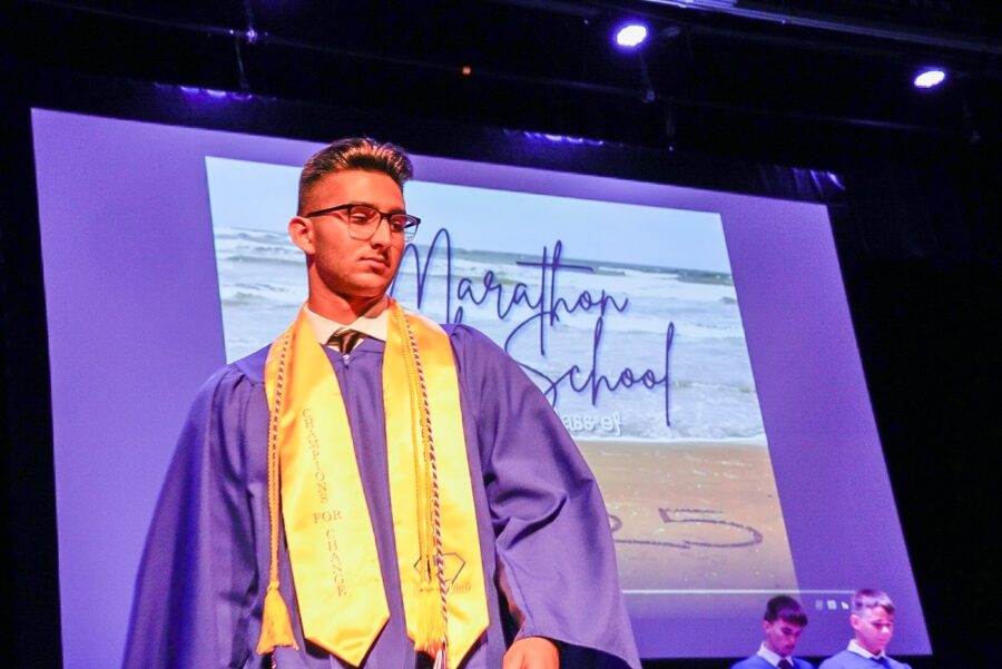 a man in a graduation gown standing on a stage