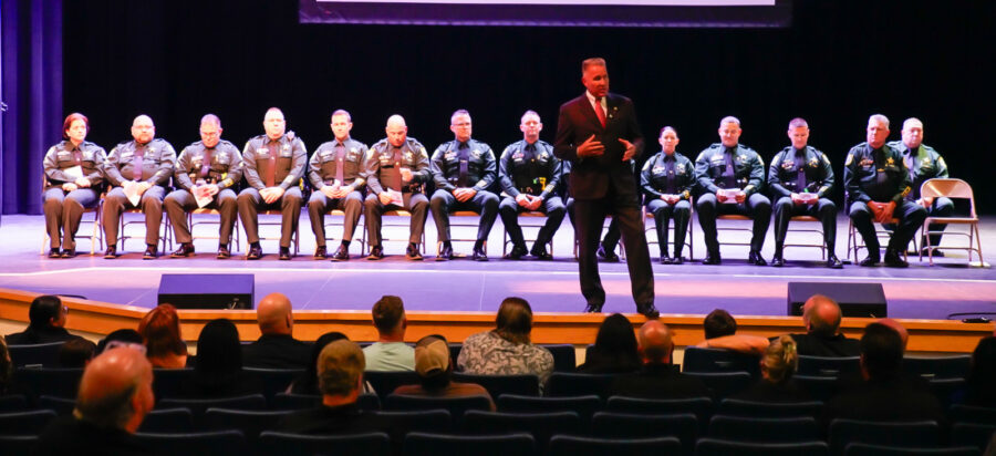 a man standing on a stage in front of a group of people