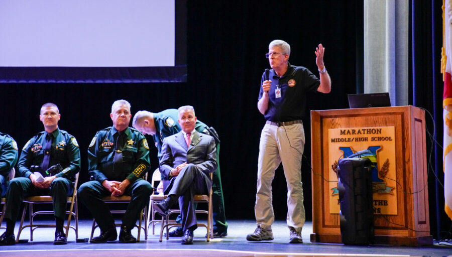 a man giving a speech to a group of people
