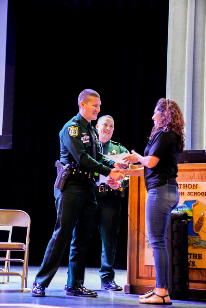 a man in a police uniform shaking hands with a woman