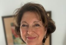 a woman in a white shirt smiling at the camera