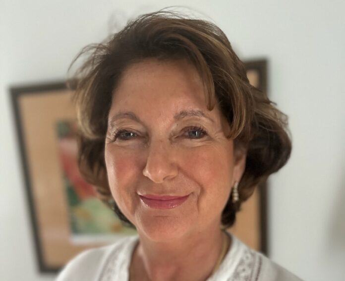 a woman in a white shirt smiling at the camera