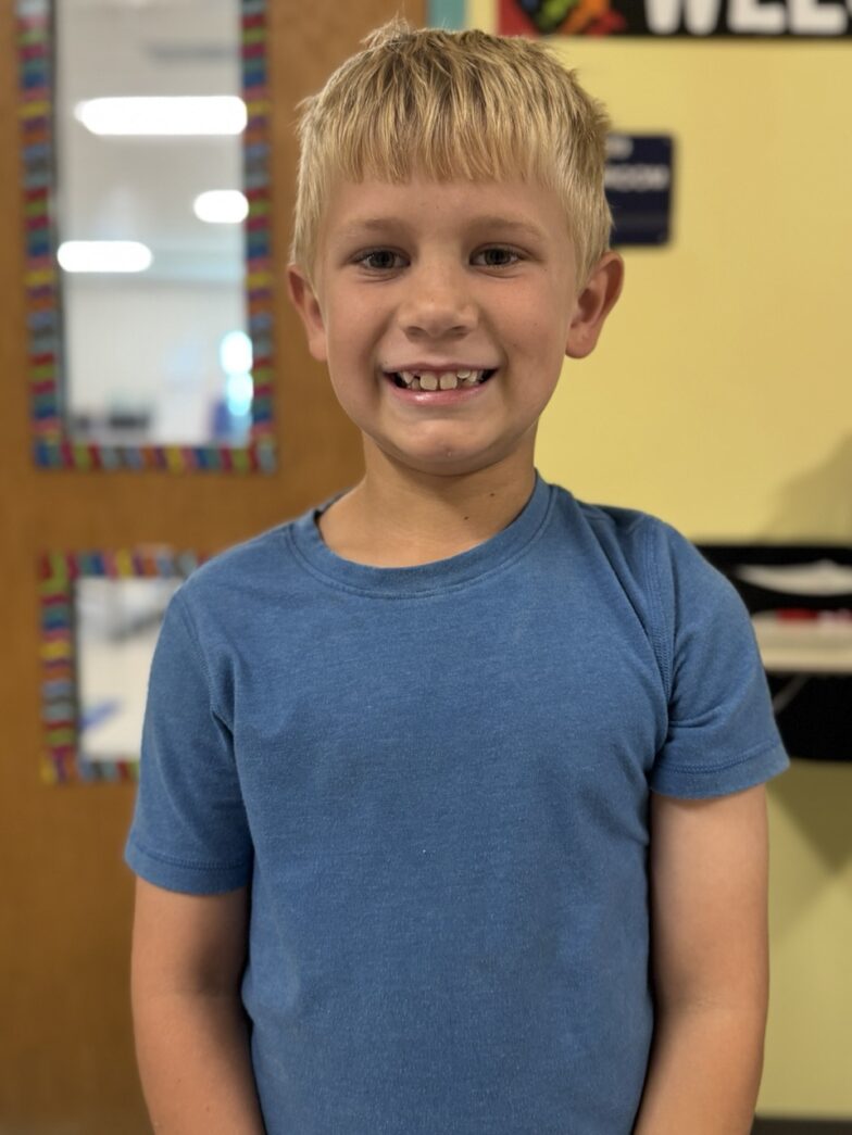 a young boy standing in front of a door