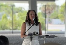 a woman standing at a podium with a microphone
