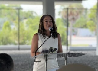 a woman standing at a podium with a microphone