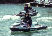 a couple of people riding jet skis on top of a body of water
