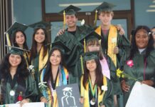 a group of people in graduation gowns posing for a picture
