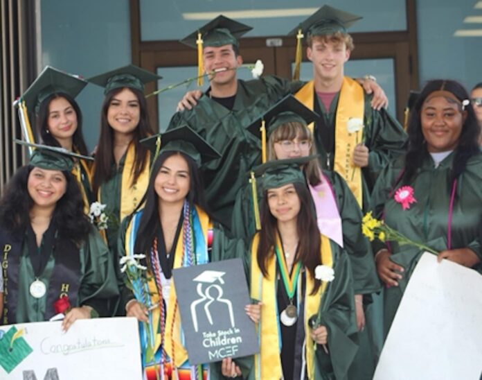 TSIC grads 2024 a group of people in graduation gowns posing for a picture