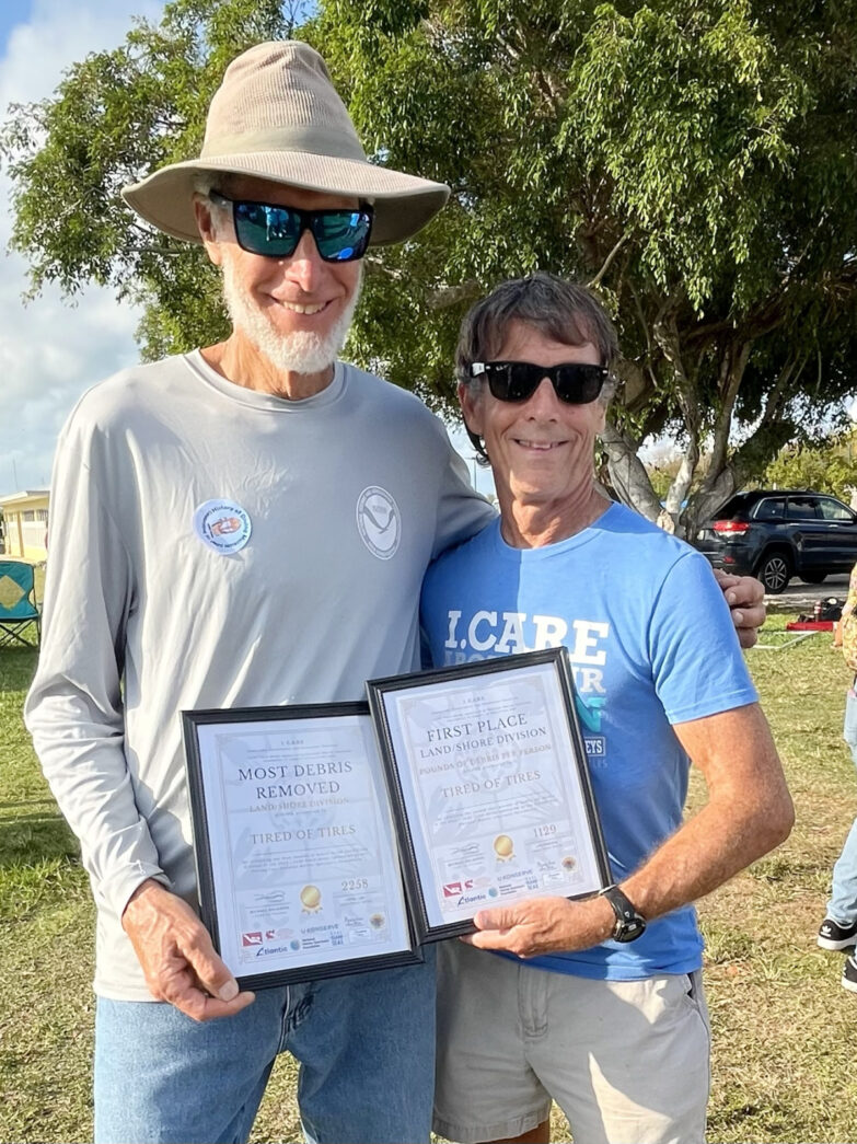 two men standing next to each other holding plaques