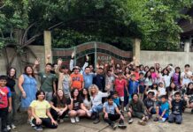 a group of people posing for a picture in front of a gate