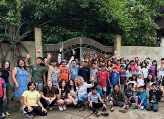 a group of people posing for a picture in front of a gate