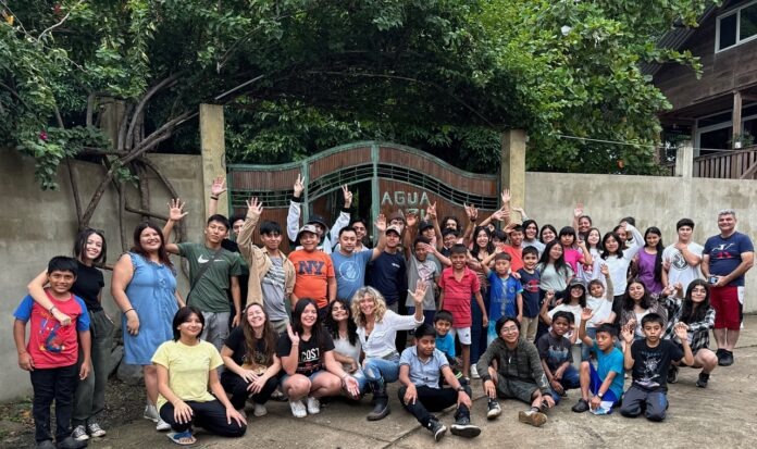 VBS a group of people posing for a picture in front of a gate