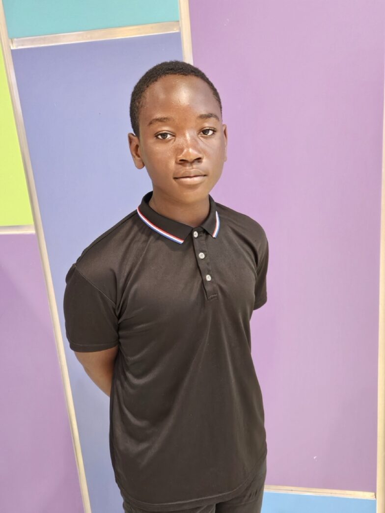 a young man standing in front of a colorful wall